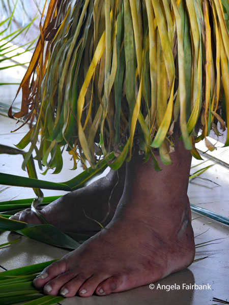 feet and grass skirt of dancer
