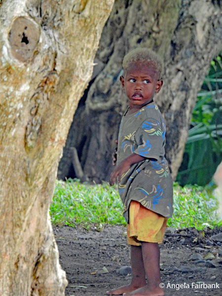 blond-haired boy by tree