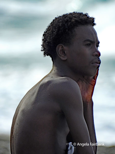 young man sitting by water