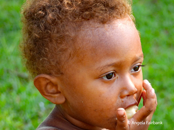 child with fingers in mouth