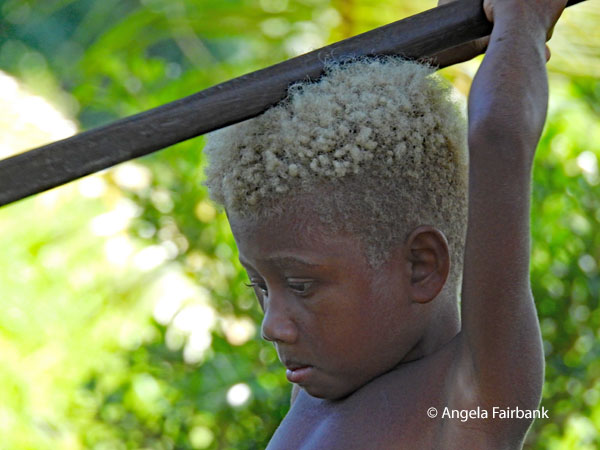 blond boy with diagonal stick