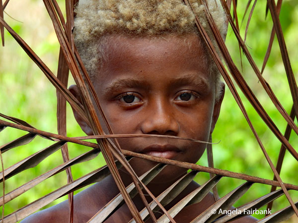 other blond-haired boy behind fence