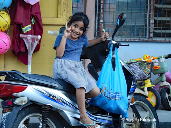 girl with groceries on a motorbike