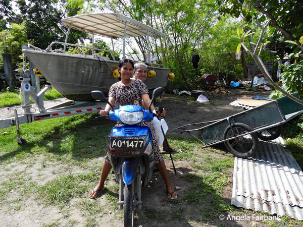 girl on motocycle with her grandmother behind sitting sidesaddle