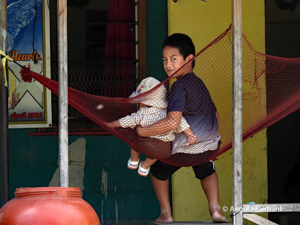 two brothers sitting on a hammock