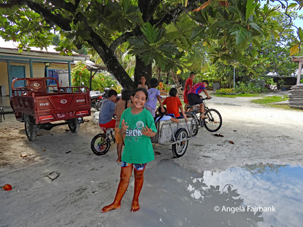 children playing with bicycles and carts