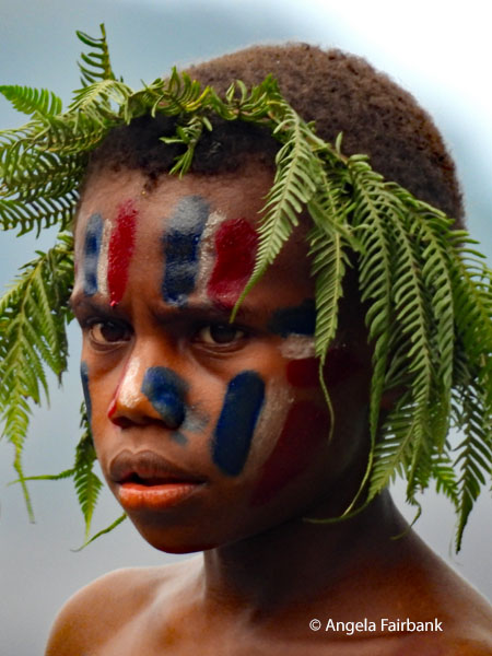 older boy with face paint and ferns