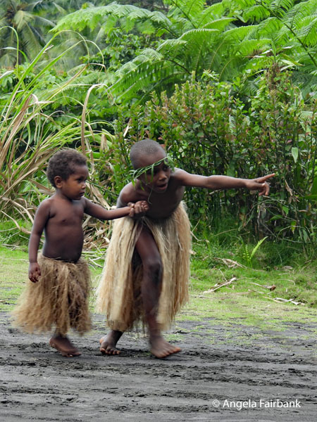 boy pointing and holding a younger boy by the hand