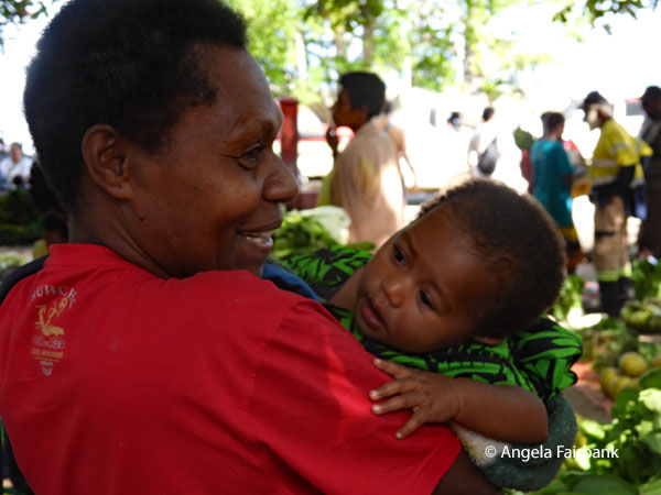 woman with baby in arms at market
