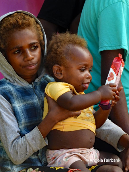 girl with baby holding a red and white package