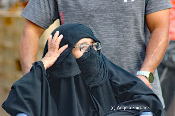 one old woman in black in a wheelchair