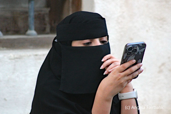woman in black checking phone