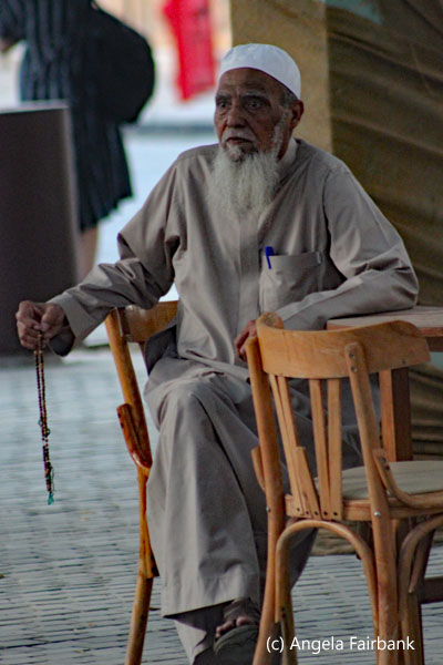 old man in clerical dress sitting in cafe
