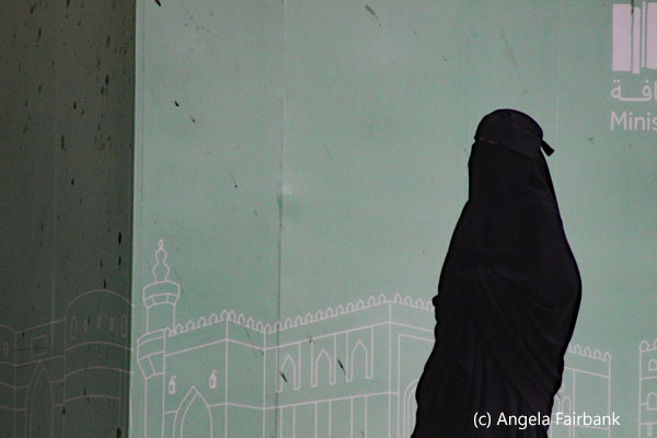 woman in black against green background