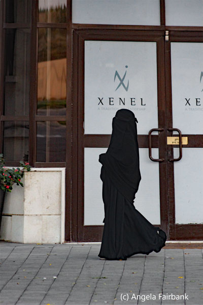 woman in black against store door