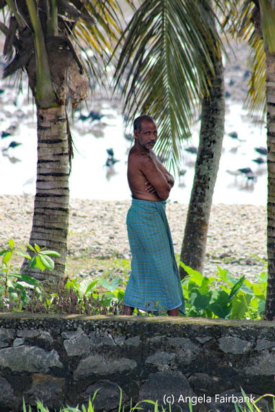 man in long skirt and palm trees