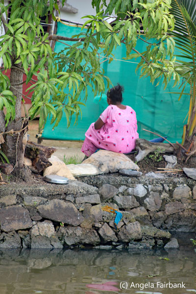woman in pink sitting on wall