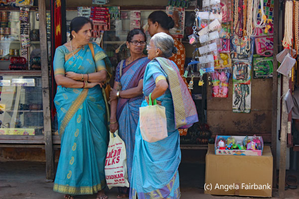 4 women chatting in front of store