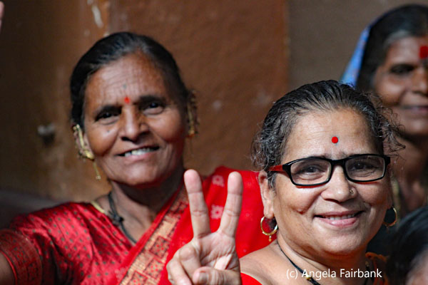 three women smiling one with peace sign