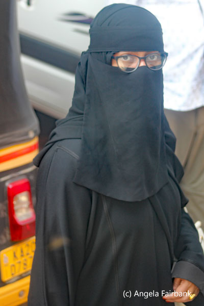 young woman in black with glasses