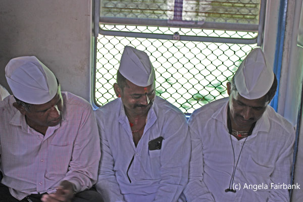 3 dabbawalas sitting on train