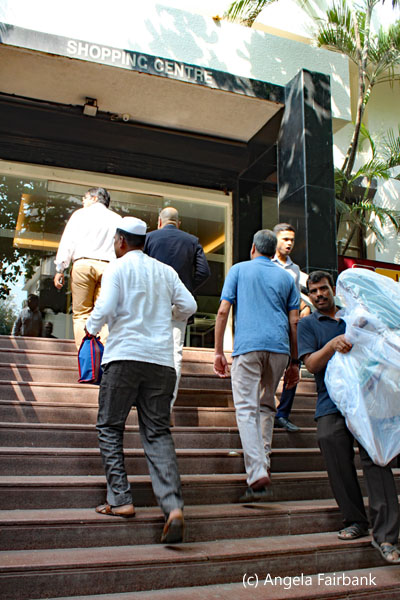 dabbawala carrying tiffin upstairs